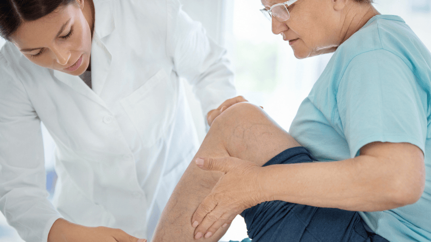 Photograph of a doctor examining a patient's leg veins