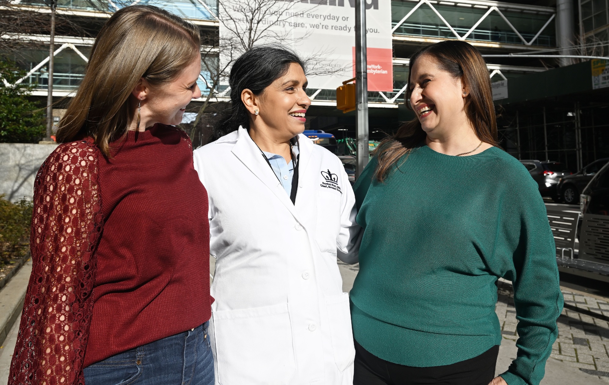 Dr Roshni Rao stands with two patients outside hospital