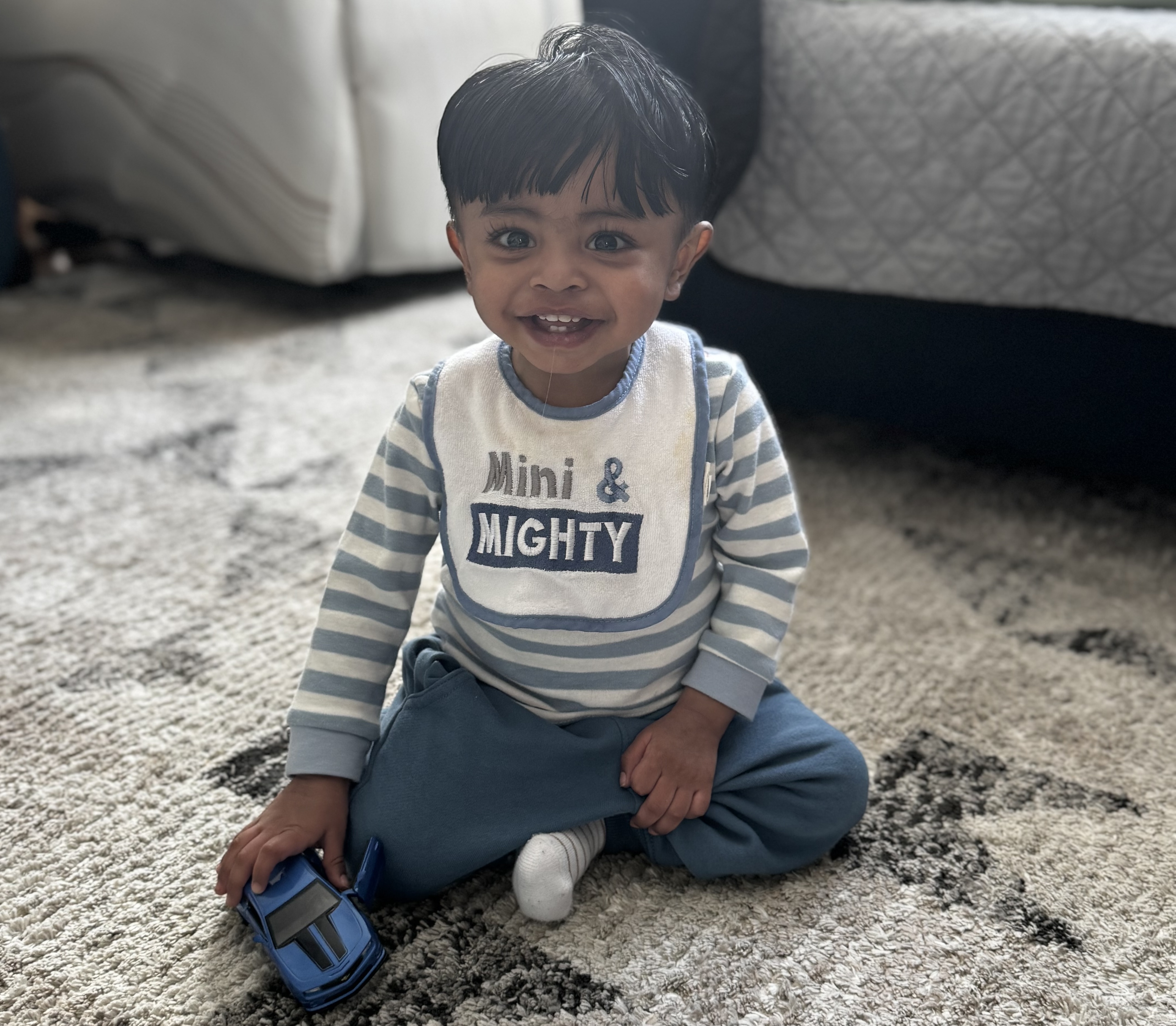 eric, a toddler, sits with a big smile