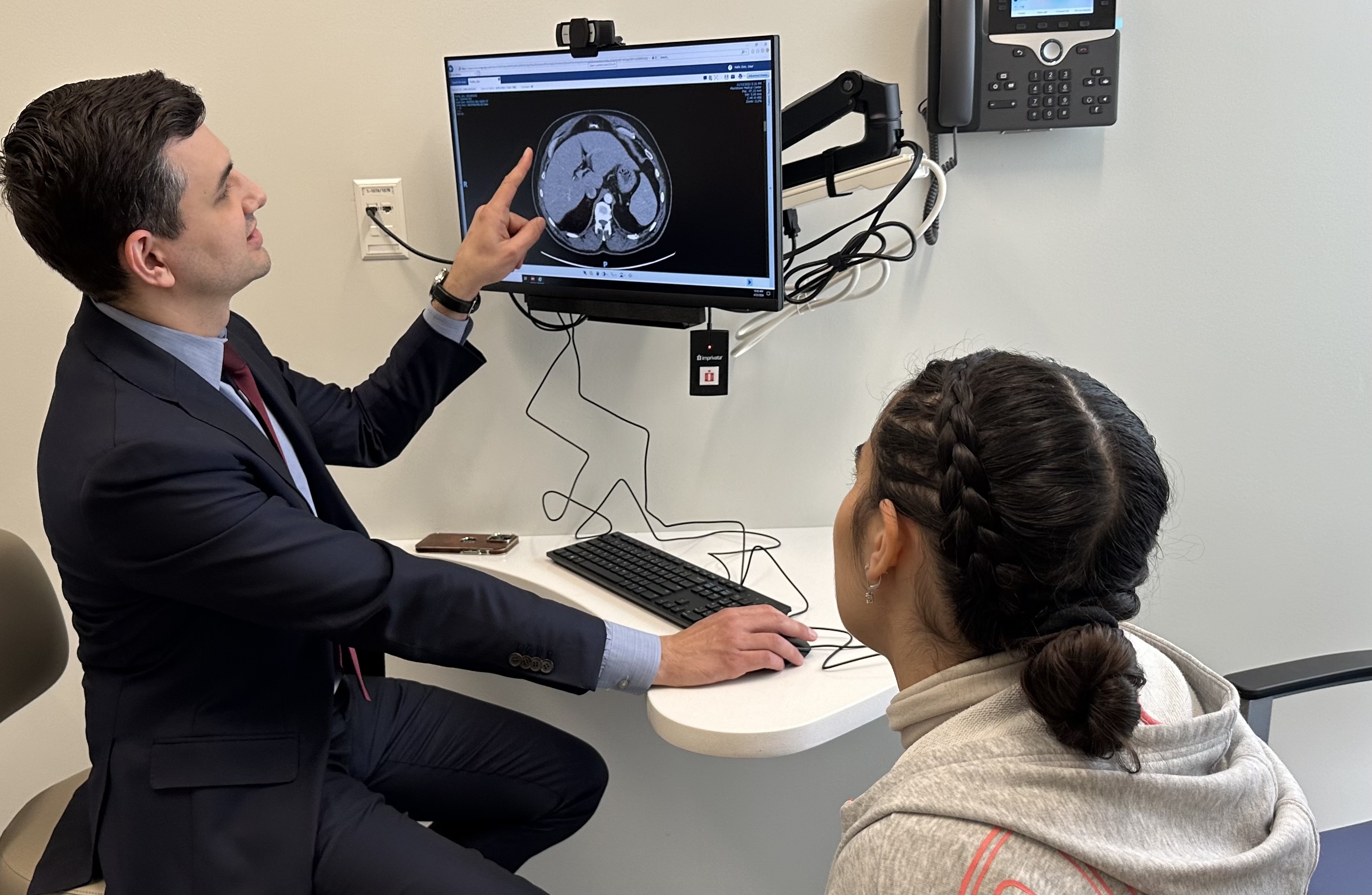 surgeon shows patient scan of abdomen