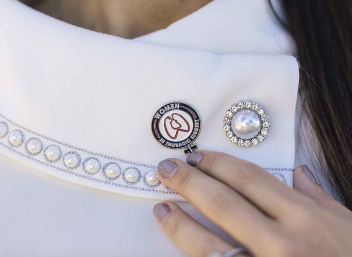 Surgeon showing her women in thoracic surgery pin