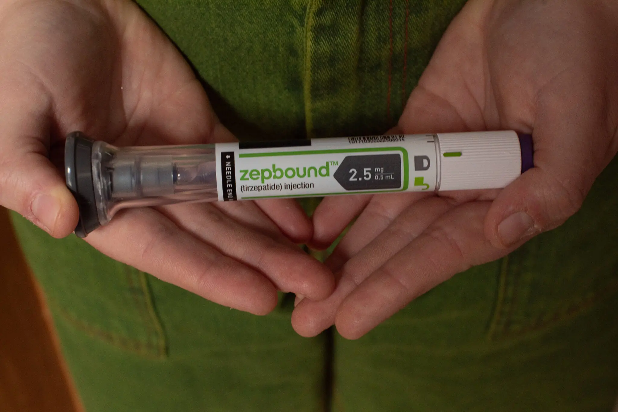 Hands holding GLP-1 injector