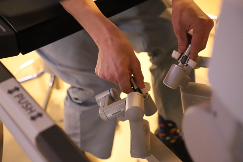 surgeon’s hands on two rotating controls from the da Vinci Xi robotic system