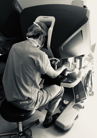 Seated surgeon looking into a da Vinci Xi robotic systemS