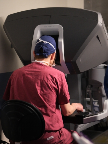 Dr. Geirrson at the consoles of the robotic surgery system