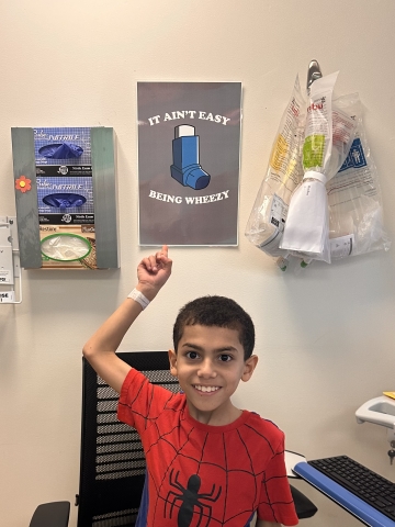 Ethan points to a sign in hospital