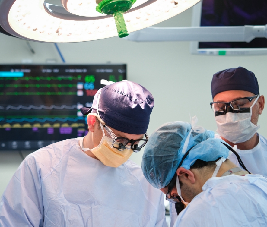 Photo of three surgeons performing a mitral procedure