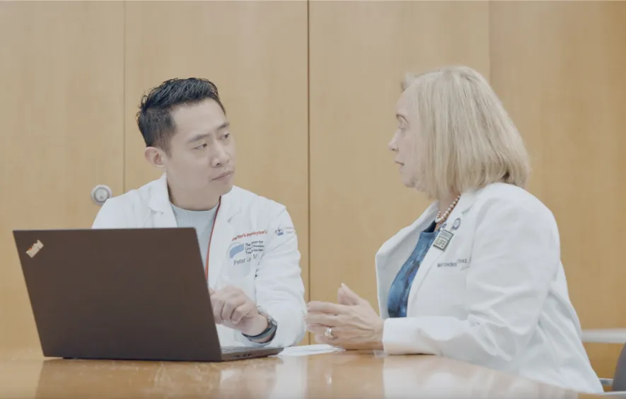 Drs sit at a computer together