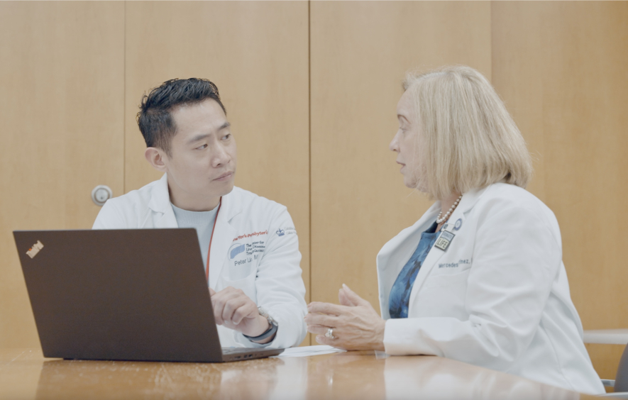 Drs sit at a computer together