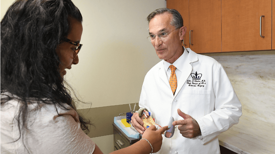photograph of Dr Chabot with patient and model of the pancreas