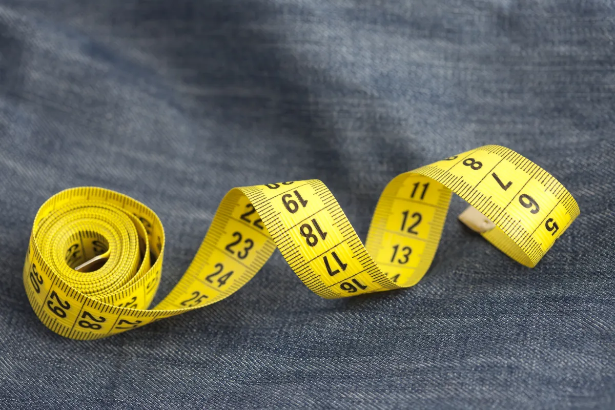 measure tape rolled up on denim