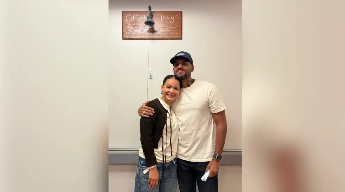 eileen and her husband stand with bell 