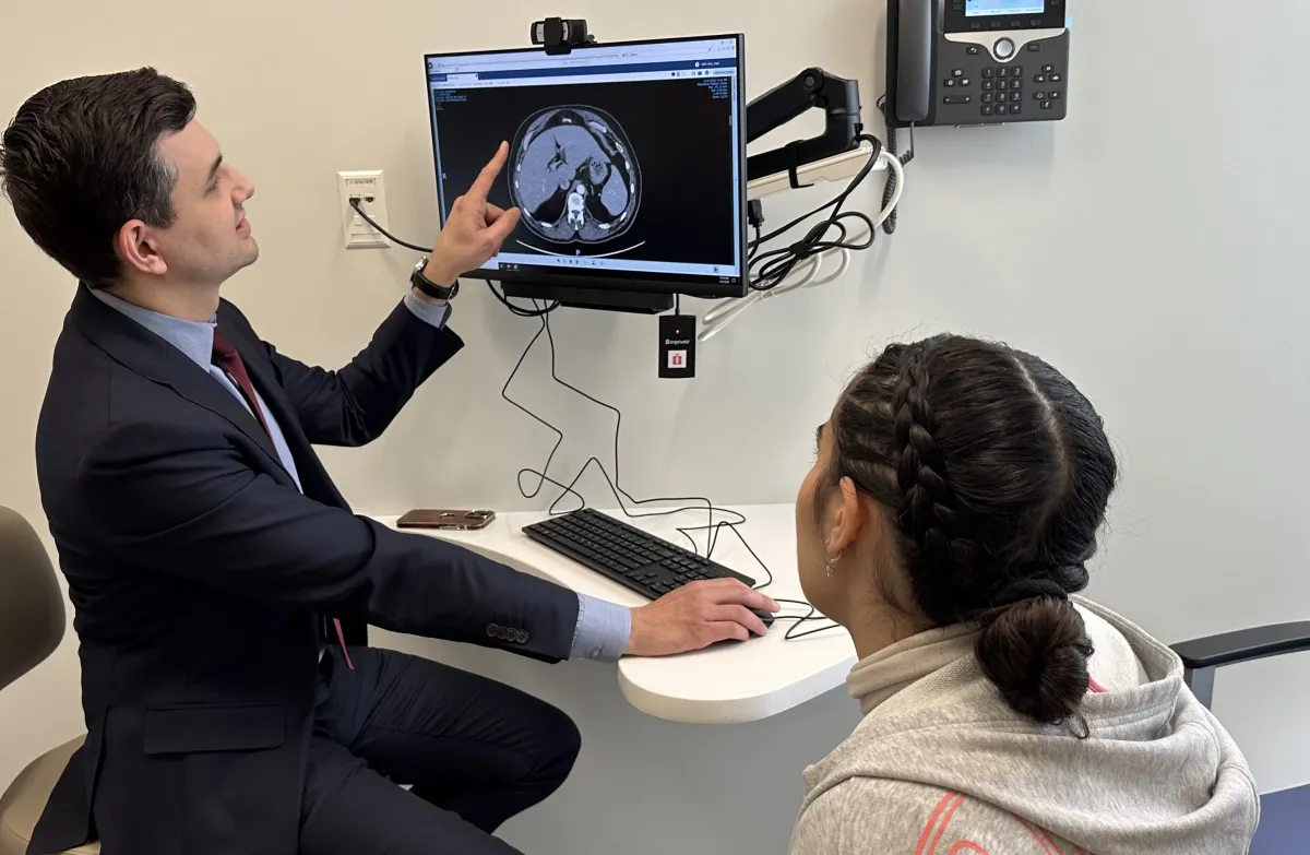 surgeon shows patient scan of abdomen