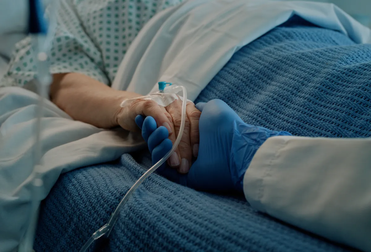  Hospital, holding hands and bed with doctor, support and care together in a clinic after surgery