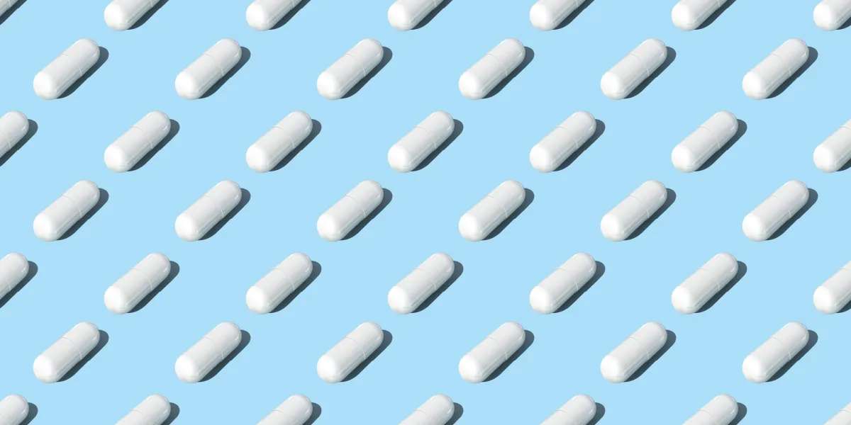 A series of rows of medical pills with a light blue background