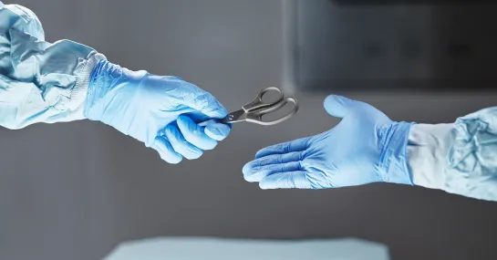 Cropped shot of an unrecognizable surgeon passing his colleague a pair of scissors