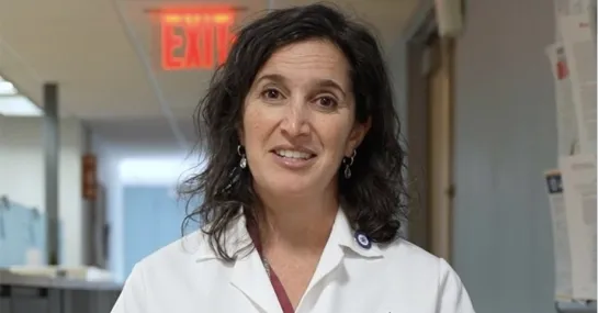 Photograph of Dr. Katherine Fischkoff standing in her Columbia University white coat.