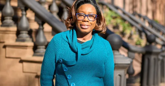 Nadine stands outside her New York City stoop
