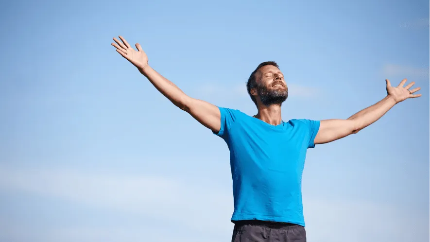 Photo of man with arms open to the sky