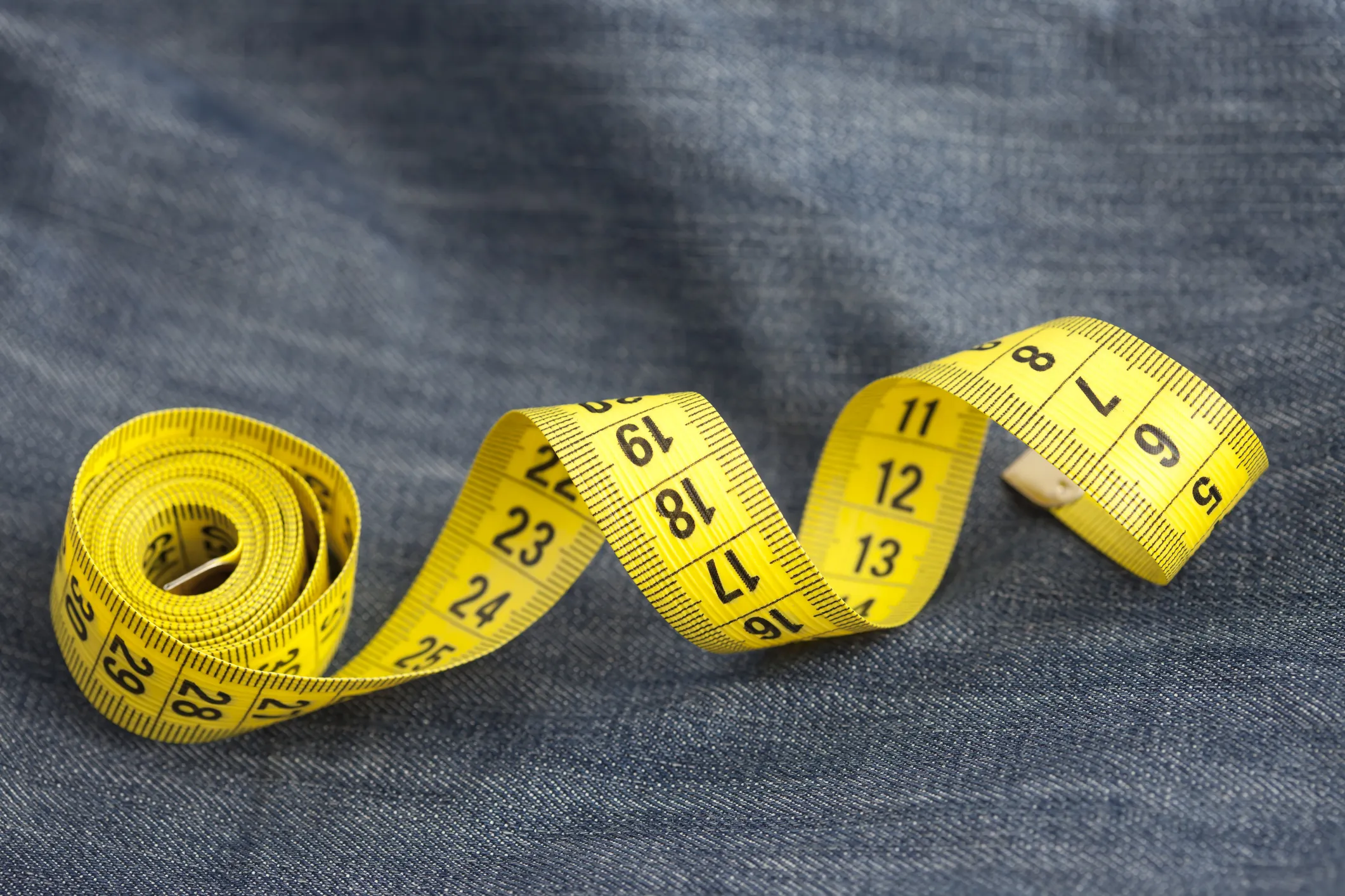 measure tape rolled up on denim