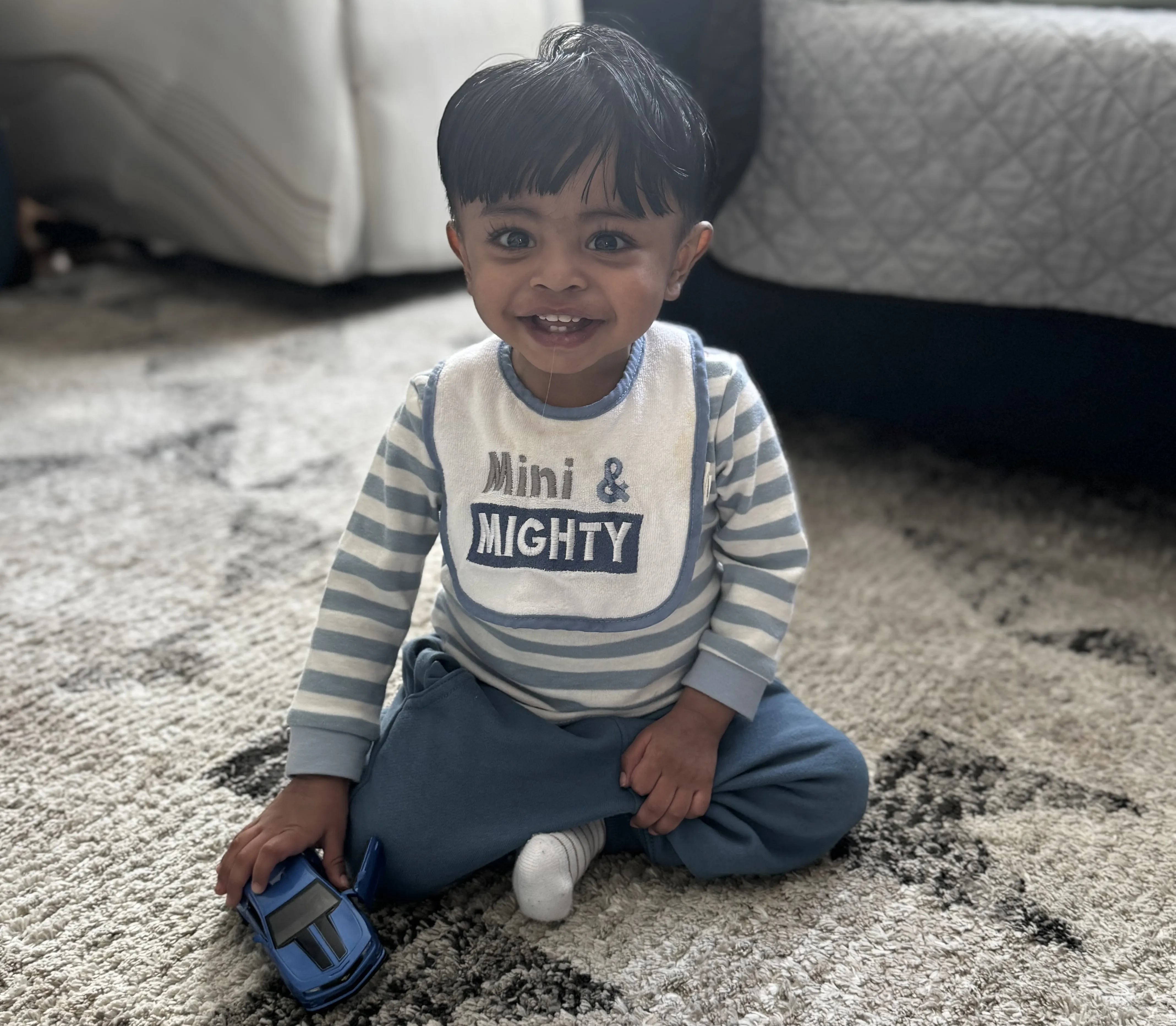 eric, a toddler, sits with a big smile