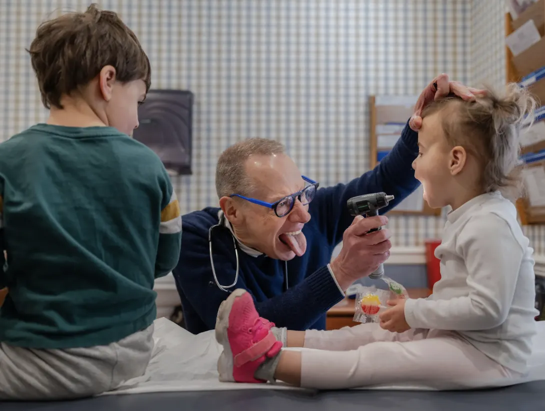 Doctor examines a kid in his office.