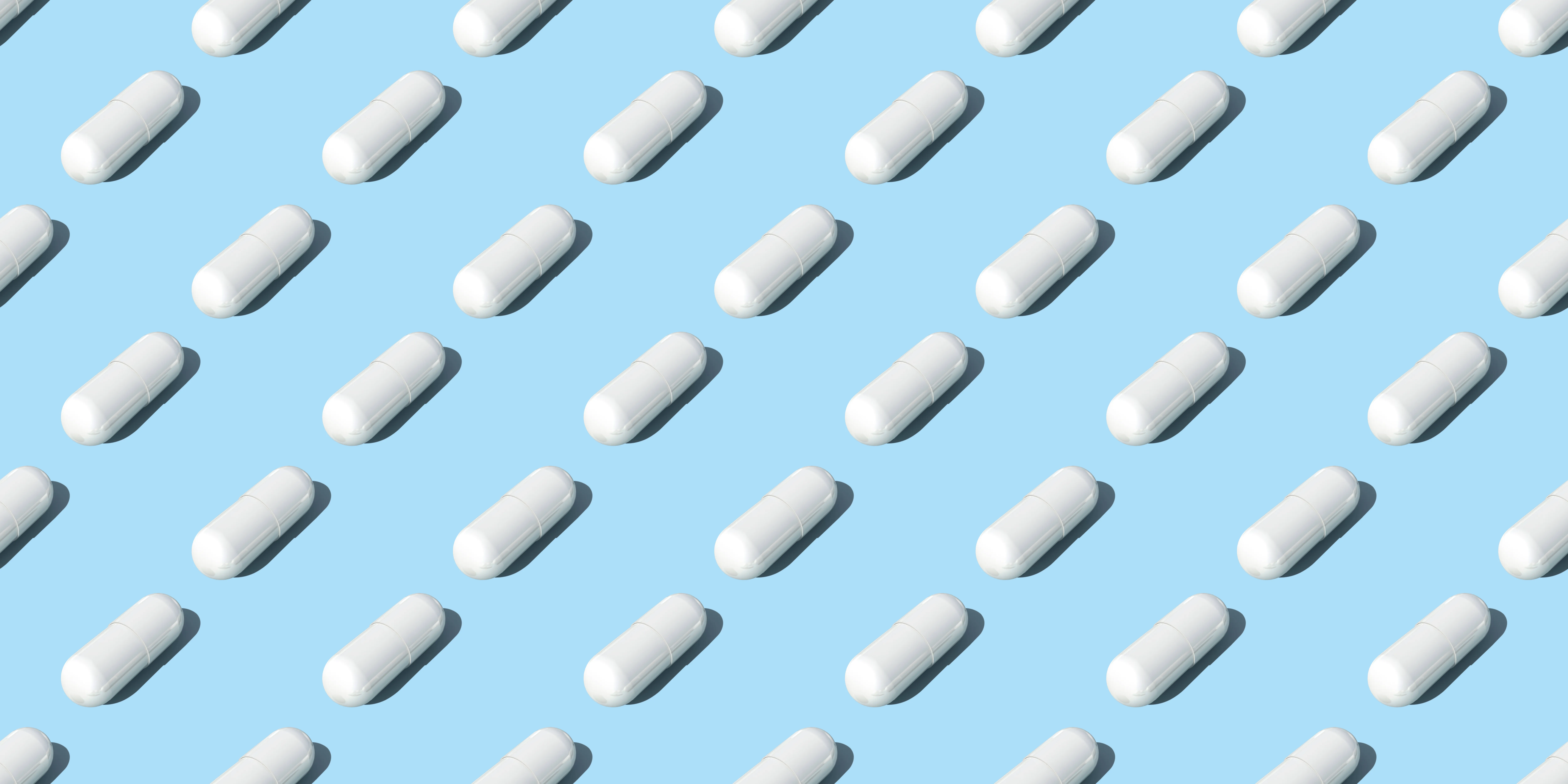 A series of rows of medical pills with a light blue background
