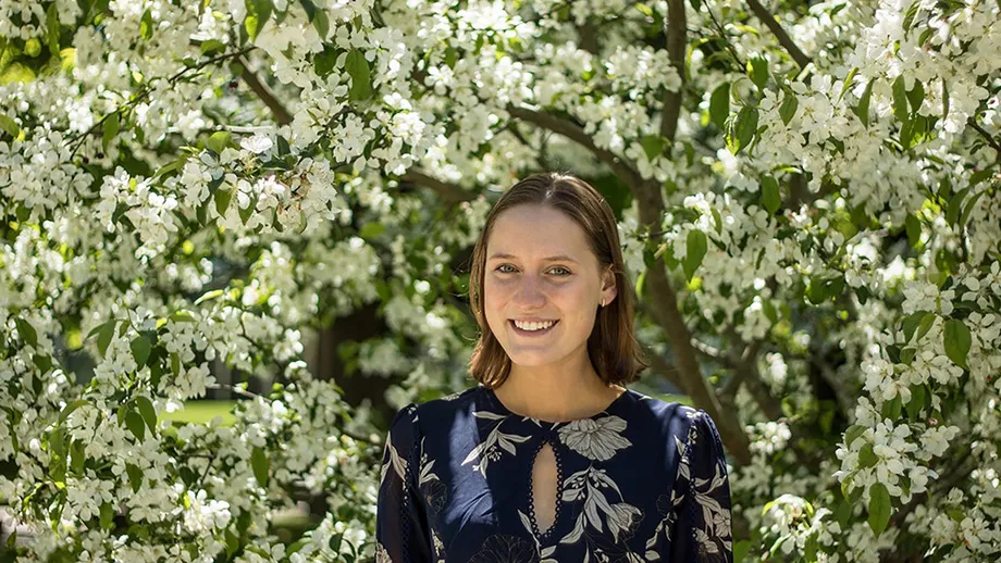 Julija Paulius stands in front of a flowering tree